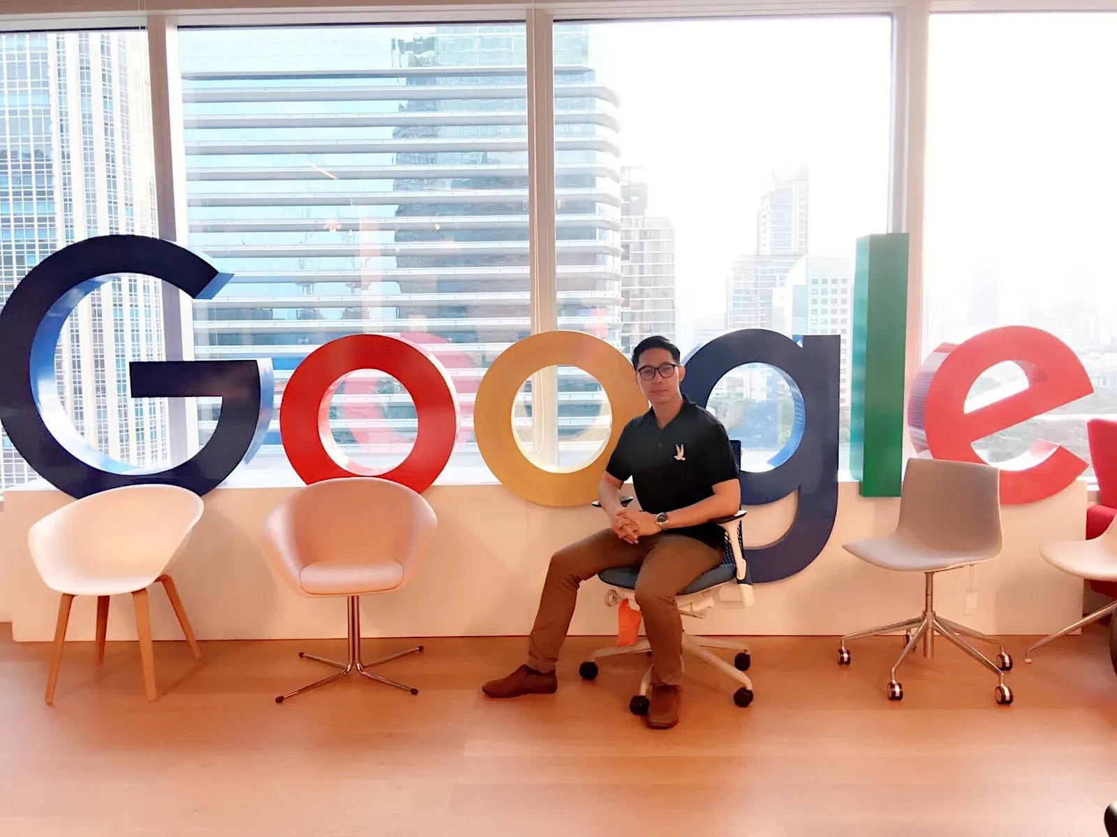 อาจารย์ เบนซ์ นั่งอยู่บริเวณป้าย Google